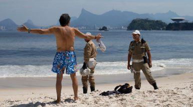 City Police asks a men to leave the beach in Niteroi, Rio region, because of coronavirus rules